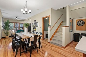Dining area with 8 chairs, dart board, and pac man arcade game