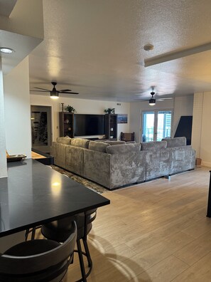 In front ,view of kitchen island w bar stools and living room