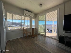 The front room is a welcoming space with a seamless connection to the outdoors. A slider door to the front patio shows a captivating view.