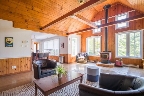 Spacious living room with high ceilings and a warm wood theme—creating an open and inviting atmosphere.