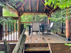 Ground-level wood terrace with a dining area—ideal for enjoying meals surrounded by nature.