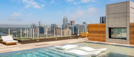 The rooftop pool features a sun shelf, cabanas, and stunning views of the Austin skyline.