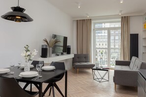 A stylish dining area with a black round table, contemporary chairs, and elegant lighting.
