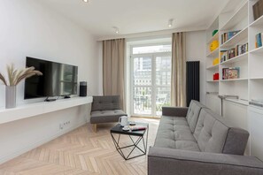 Another angle of the living room with a grey sofa, TV, and stylish decor, creating a relaxing ambiance.
