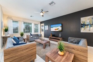 Relax in this stylish living room with modern decor, ample natural light, and a cozy ambiance perfect for unwinding.