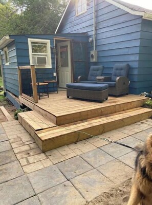 Rear deck with reclining lounger, foots rest, and small dinette with 2 chairs