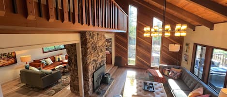 Living Room with double vaulted ceilings, redwood accent walls, and a fireplace