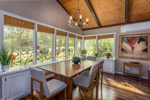 Dining Area with Chandilier - custom Glass windows with views of lush green