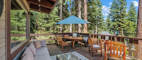 Front deck with plentiful outdoor furniture and partial lake view