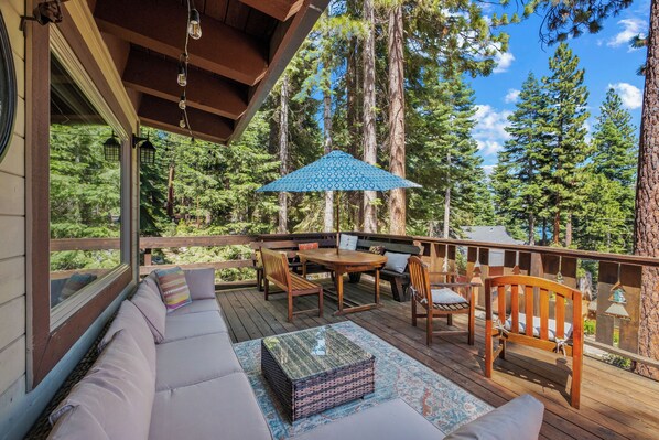 Front deck with plentiful outdoor furniture and partial lake view