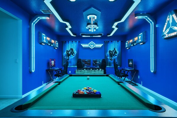 Futuristic gaming lounge with neon lights, pool table, and high-tech setups.