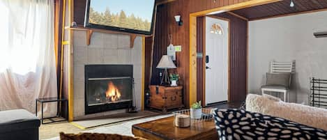 Modern mountain interior design with a fireplace and TV in the cozy living room.