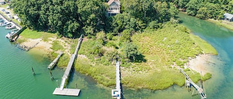 A breathtaking bird's-eye view capturing the expansive property, complete with a stretching private dock reaching out into the serene waters.