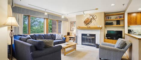 Spacious living room with soothing bright colors.  Natural light from the large windows which offer a serene views of the surrounding landscaping of Highridge