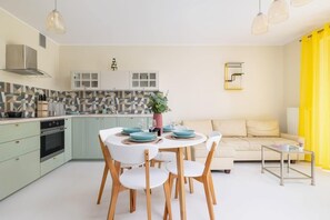 A dining area with a wooden table and chairs, complemented by a bright and airy atmosphere.

