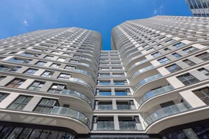 A striking exterior view of a modern high-rise building with a unique curved design.

