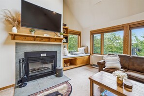 Living room w/wood burning fireplace.  Lots of comfortable seating for your pleasure. Large windows filtering in the abundance of natural lighting.  Grab a book and sit in the window seat while enjoying the nature of Vermont!