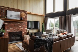 The rustic charm of the brick wall adds a cozy touch to this spacious living room.