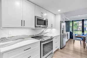 Brand new kitchen with stainless appliances and quartz counters