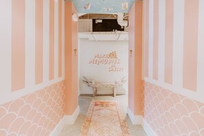 Vacation starts here! This playful entryway sets the tone with pink stripes, scallop trim, and pure personality.
