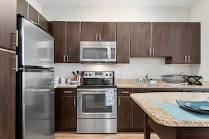 The well equipped kitchen has stainless steel appliances and is outfitted with everything you need to cook a good meal at home.