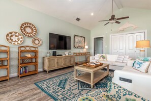 Beautifully decorated living room with large TV and plenty of seating.