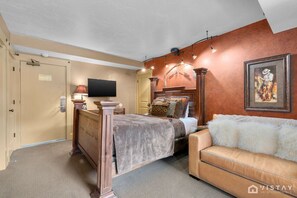 Master bedroom featuring a comfortable king-size bed, an additional sofa bed, a flat-screen TV, and access to a private balcony—perfect for relaxing and enjoying the views.
