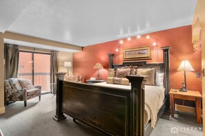 Bedroom 2 offers a comfortable queen-size bed and a cozy single-chair sofa nook, perfect for unwinding with a book or enjoying some quiet time.