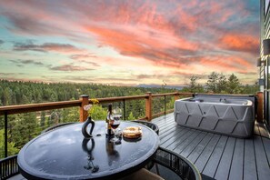 Expansive deck w/ table & chairs and hot tub. Mountain, pond, and forest views.