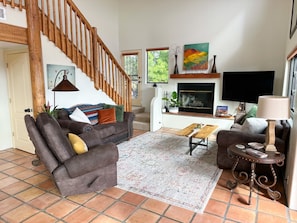 Living room with sofa, loveseat and rocker recliner. Wood burning fireplace.