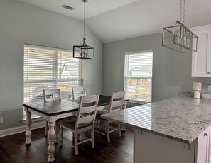 Dining with seating for 6+ with table and barstools.