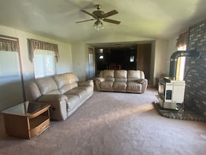 Large family room with a cozy fireplace and views to the backyard and mountains.