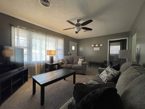 Living Room with Love seat and sofa, coffee table and 2 side tables and Roku TV.