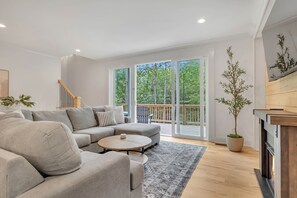 View of the woods from the large sliding glass door and living room sectional.