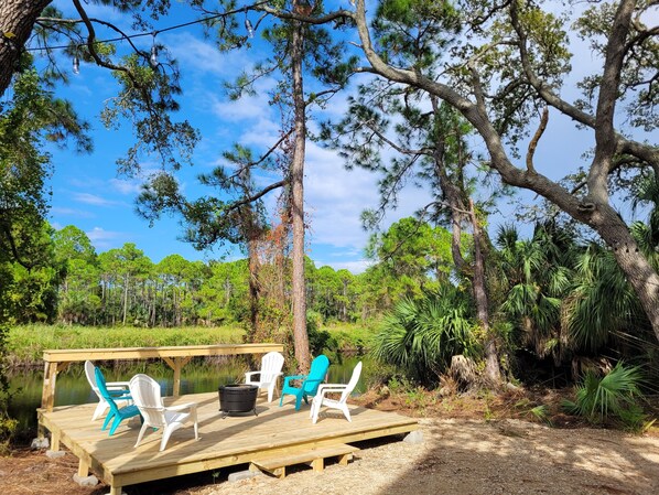 Deck with fire pit and standing bar adjacent to freshwater canal