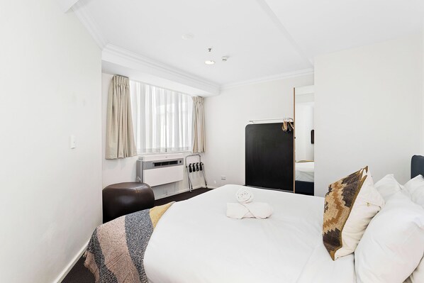 Retreat to this cozy queen bed, featuring a soft linens. It's the perfect place to rest and recharge.