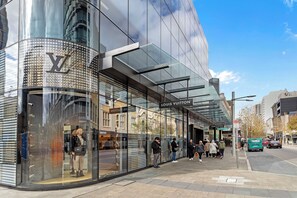 Discover the vibrant city life just steps from your doorstep! Indulge in world-class shopping at luxury boutiques like Louis Vuitton.