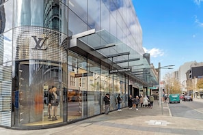 Discover the vibrant city life just steps from your doorstep! Indulge in world-class shopping at luxury boutiques like Louis Vuitton.