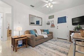 Living room with smart TV and sofa bed.