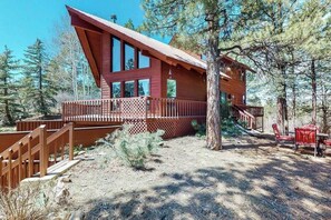 A side view of the home with a dining area amongst the trees.