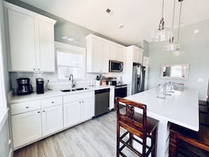 Elegance meets efficiency in this immaculate, well-appointed white kitchen.