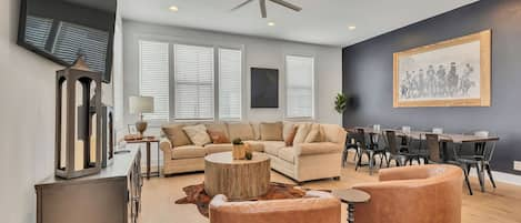 Inviting living area with a huge smart tv, custom design touches, and plenty of seating to gather and dine with your group.