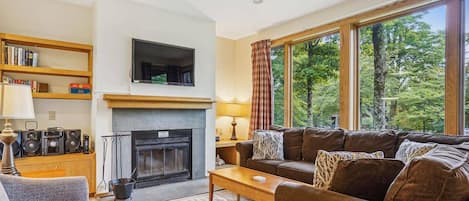 Enjoy the rich warm colors while lounging in comfort and taking advantage of the wood burning fireplace. Large windows filter in tons of natural light and frame the surrounding scenery.