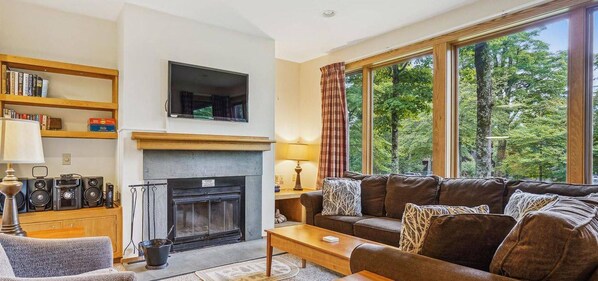 Enjoy the rich warm colors while lounging in comfort and taking advantage of the wood burning fireplace. Large windows filter in tons of natural light and frame the surrounding scenery.