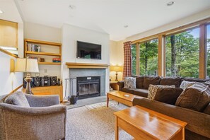 Enjoy the rich warm colors while lounging in comfort and taking advantage of the wood burning fireplace. Large windows filter in tons of natural light and frame the surrounding scenery.