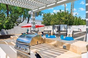 Outdoor kitchen w/ 4 bar stools and pergola