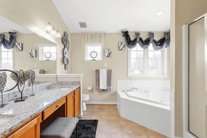 Full ensuite master bathroom with jacuzzi tub, standing shower with glass doors and double vanity.