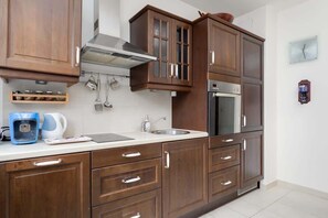 A well-equipped kitchen featuring wooden cabinetry, modern appliances, and a clean layout.
