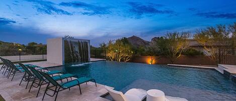 Night sky poolside w/ unique waterfall feature, spa, & pool loungers