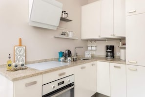 A modern kitchen with white cabinets, granite countertops, and high-quality appliances for a functional cooking space.